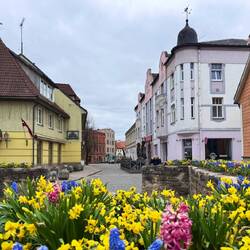 Rundherum ziehen sich kleine Gassen mit Holzhäusern, Cafés und Blumenfenstern durch die Altstadt.