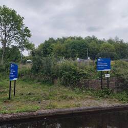 Signs signalling the junction of the Ashton and Huddersfield Narrow Canals at Whitelands Basin