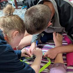 Hanna und Arved bestimmen Lauras Beinlänge, um den Sattel richtig einzustellen