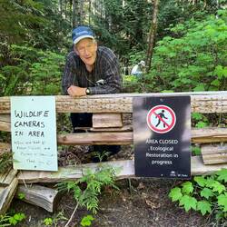 Mike at end of Laura Cove trail, standing at sign at Melanie Cove end!