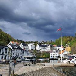 Tvedestrand. Flag blowing one way, ominous clouds from other