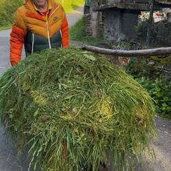 A cheerful farmer with a content cat having a ride.