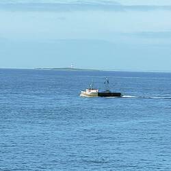 Oyster boat and Stirling Point Lighthouse in the distance