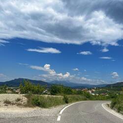 Des petites routes qui serpentent sur les coteaux albanais avec les montagnes au loin
