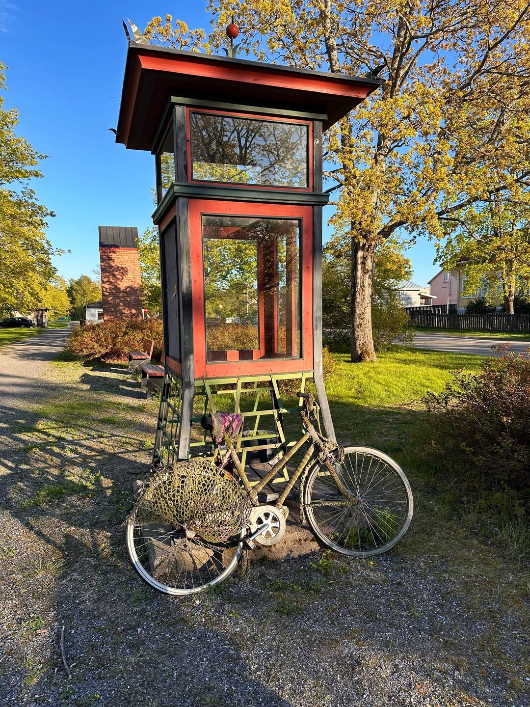 Alte Telefonzelle mit moosbewachsenen Fahrrad