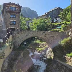 A small stream slips under an old stone bridge