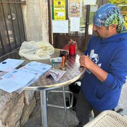 A pilgrim offering wax stamps for our passport.