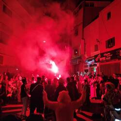 Musikgruppe zieht durch die Straßen, die Lichtschow mit Bengalos gehört wohl dazu 🥁