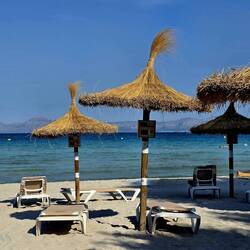 Iconic straw umbrellas with a distinctive top tuft or "tassel."