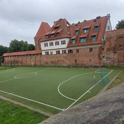 A football pitch by an old defensive wall.