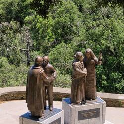3 views of the same statue. Trees in background