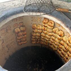 Cuisson des SOMSA au feu de bois, sur les parois d'un four de terre