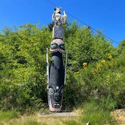 A smaller totem in front of the Long House.