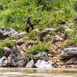 You'd spot plenty of people on the river shores: gold panners.