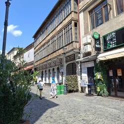 Traditionelle rumänische Architektur mit großen Holzfensterfronten im Obergeschoss.
