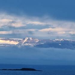 .... der Seil Licht auf die Berge jenseits des Fjords wirft