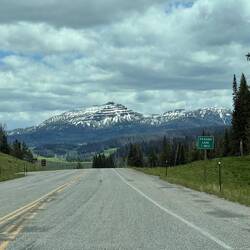 Back on the highway… and the mountains are still holding onto last night’s storm.