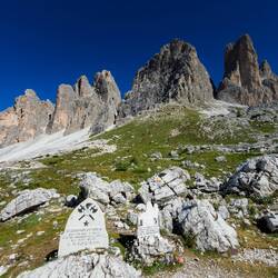 Memorial plaques near the church with Tre Cime in the background.