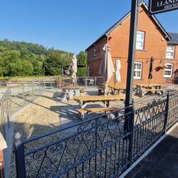 Beer garden at the front of The Lion Inn looking out to the camping field beyond beside the Severn