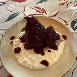 Pear poached in wine with cheese sauce.