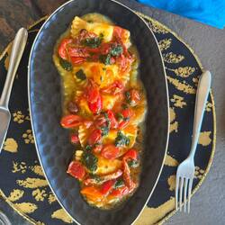 Cheese-filled mezzalune with tomatoes, sun-dried tomatoes, basil, and olives