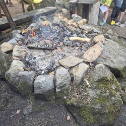 Die Feuerstelle im Dorf. Mit erhitzten Steinen wird Wasser zum Kochen gebracht