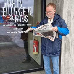 Man(n) liest vor den "Dirty Burger and Ribs" isländischen Zeitung