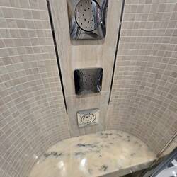 The shower has a bench and 3 jets, along with rain shower head