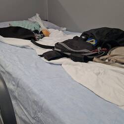 You lay some minor belongings to claim your bed