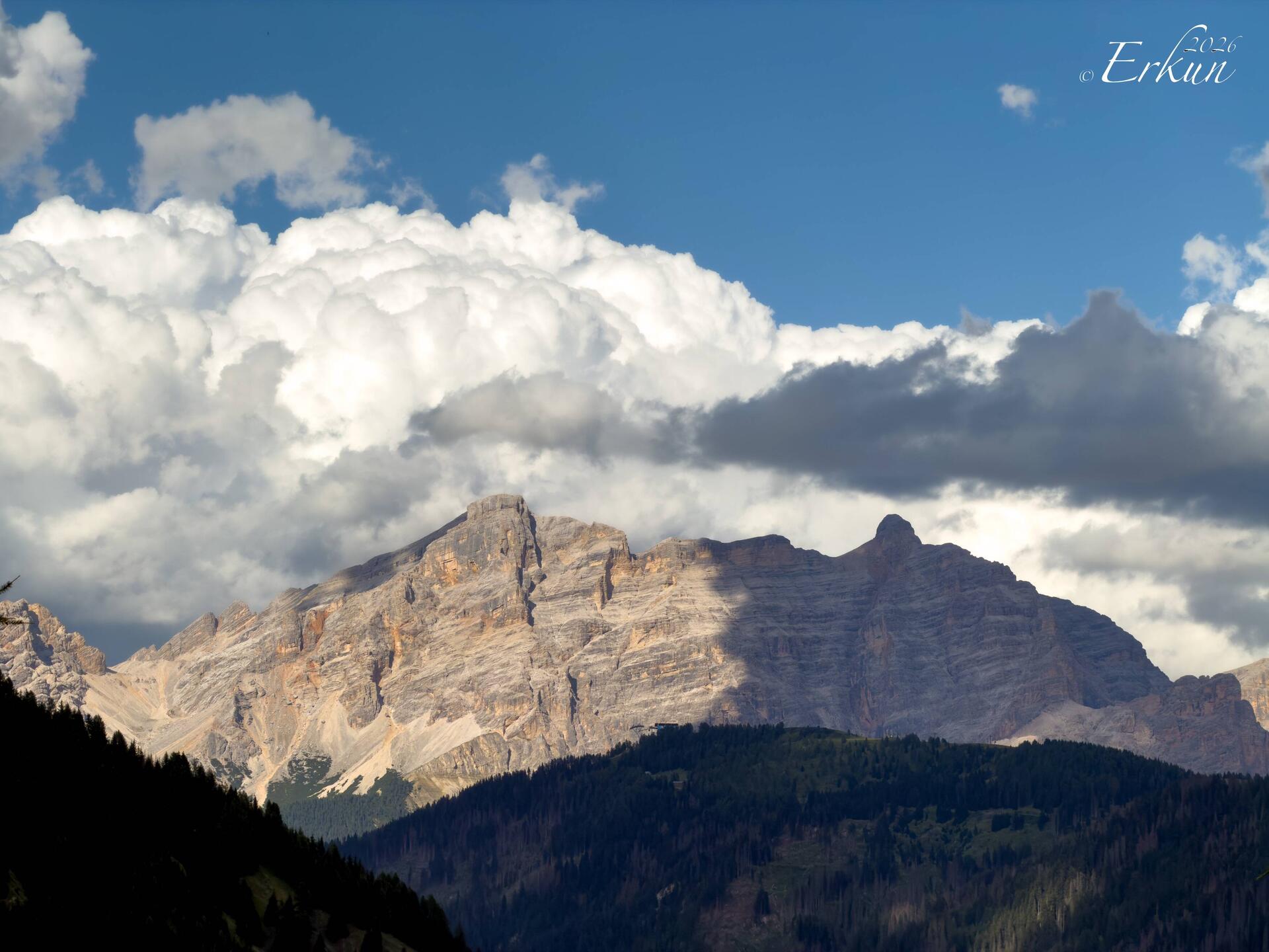Early evening thunderheads forming behind the mountains — Colfosco, Italy.