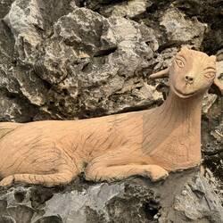 Happy goat perched on the grotto