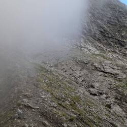 An der Scharte angekommen steigen die Wolken vom Tal auf.