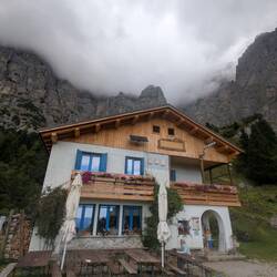Das Rifugio 7° Alpini vor der wolkenverhangenen Schiara.