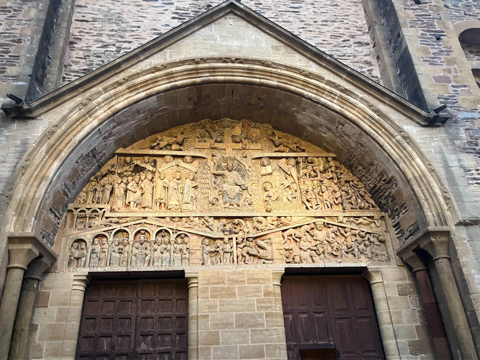 Detail. Christ enthroned at Tympanum's center. The elect to his right angels to right.