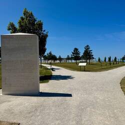 ...entlang von Steinsäulen mit Inschriften. Der Weg teilt sich zum Memorial und dem Gedenkfeld