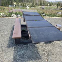 Solar panel on the picnic table with batteries connected underneath.