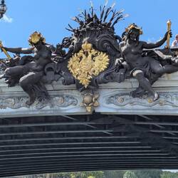 Pont Alexandre III: Nymphen der Newa mit dem kaiserlichen Wappen Russlands