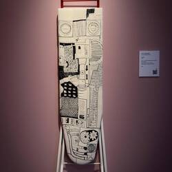 "Ironman" (J.K. Raustein; 2002); linen canvas, machine & hand embroidered, mounted on ironing board.