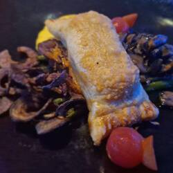 Kartoffel-Parmesan-Strudel mit gebratenen Kräutersaitlingen, geschmolzener Tomate und Curryschaum