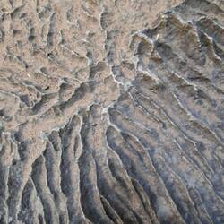This is a rock. The patterns are filled with sand