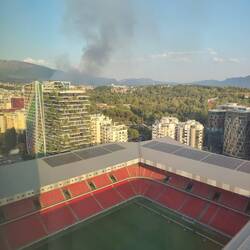 Aussicht von unserem Hotel in Tirana in ein Stadion. Zudem sieht man im Hintergrund einen Waldbrand