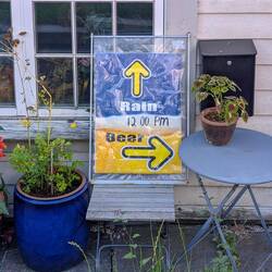 Ein typisches Bergen-Schild. Regen von oben, Bier nebenan.