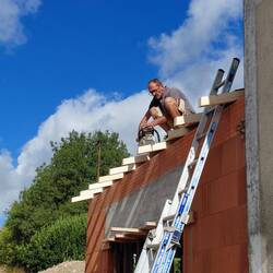 Patrick the carpenter trimming the rafters. There are no eaves on French maisons