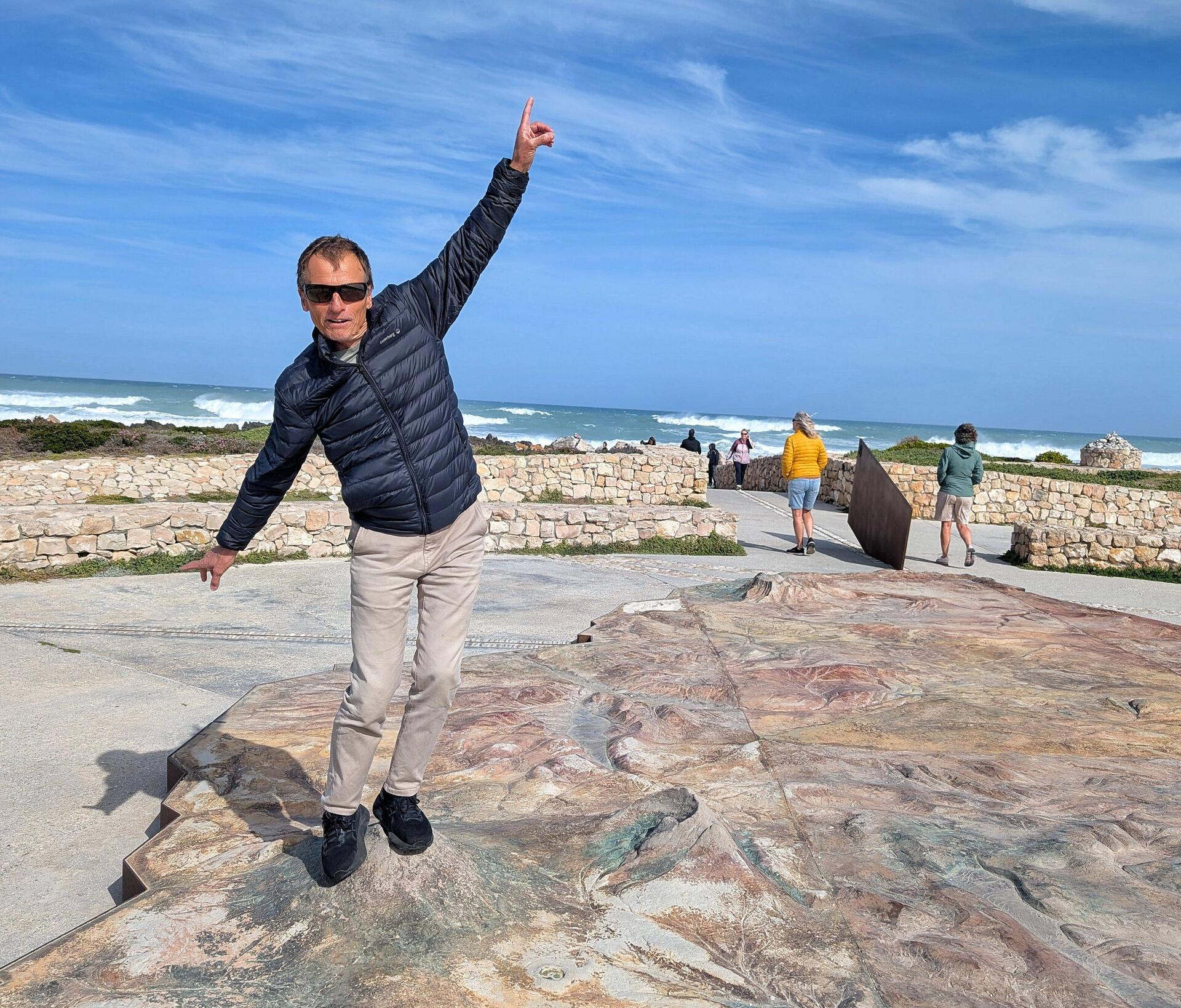Peter summiting Mt Kilimanjaro on the 3d relief map of Africa at Cape Agulhas
