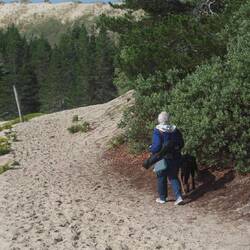 Jill and Indy walking the sandy trail