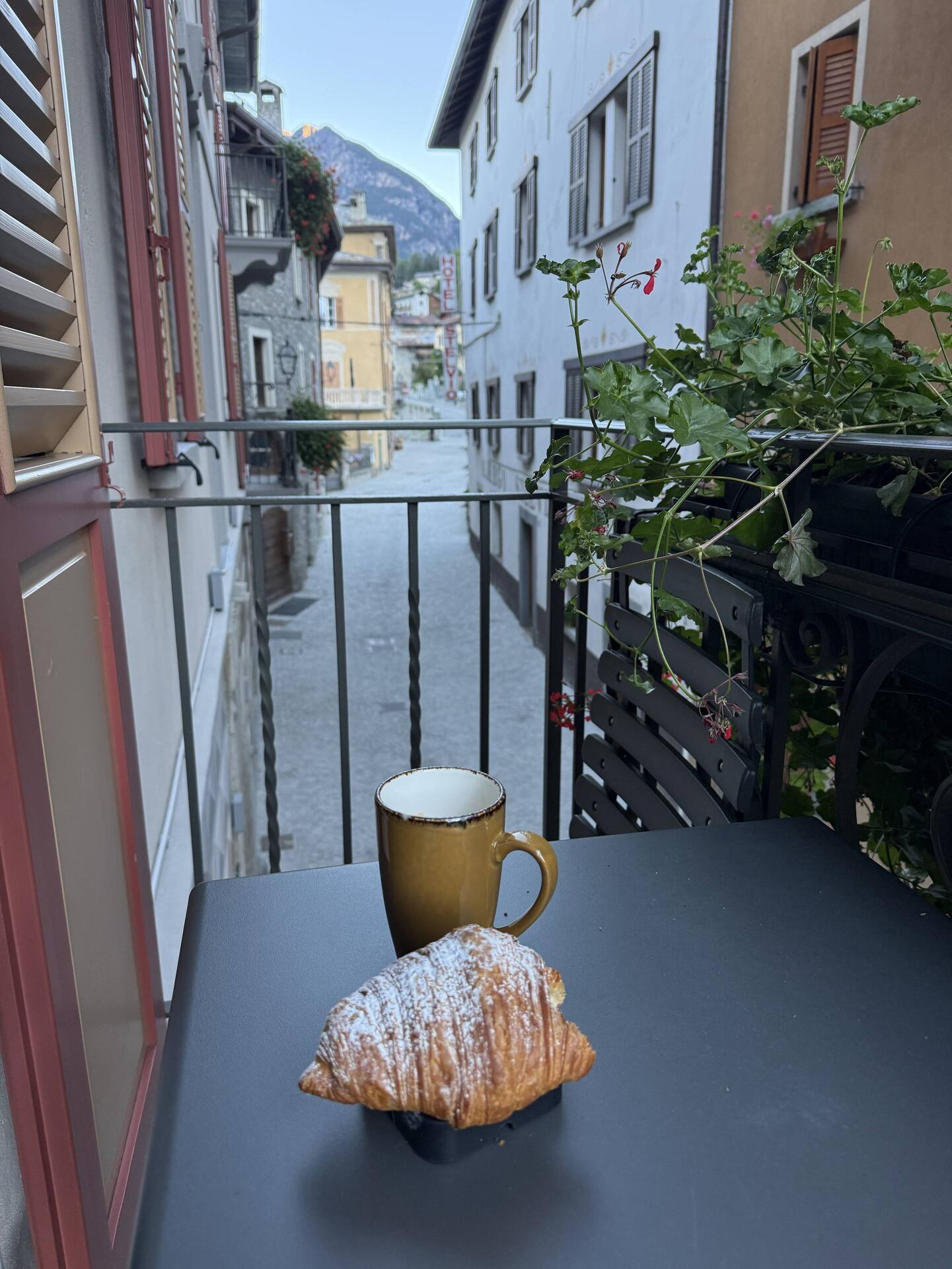 Caffè con croissant nella luce mattutina alpina
