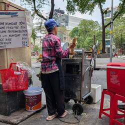 Nice lady squeezing sugar cane for juice. She ran down the street and got me a bucket to sit on.