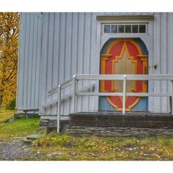 Die Tür der Kirche in den traditionellen Farben der Samen, Rot, Grün, Blau und Gelb.