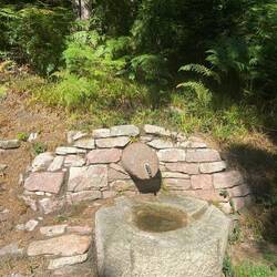 Ausgetrockneter Brunnen, im Trog nur etwas Regenwasser der letzten Nacht
