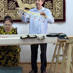 The pattern is stitched on the material and the covered with gold embroidery